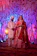 Bride and groom smiling under a beautifully decorated floral wedding mandap.