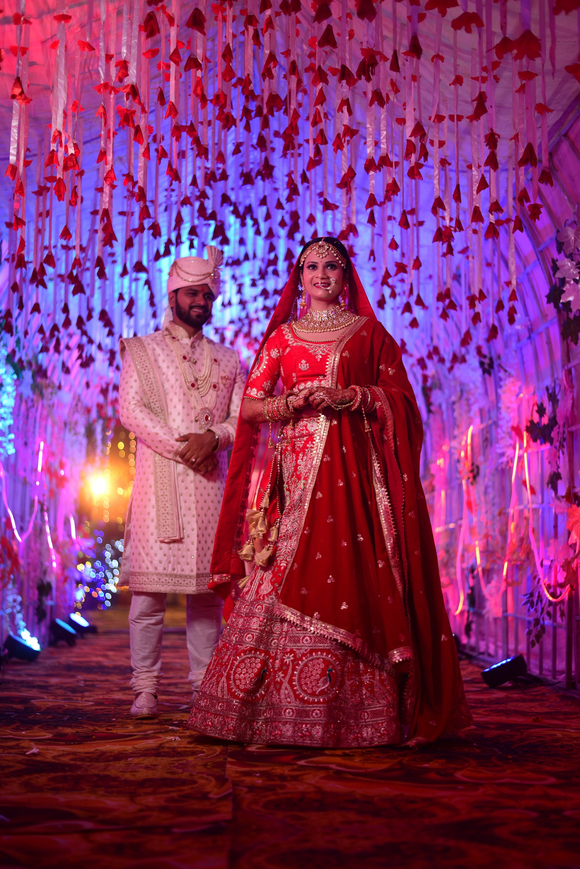 A vibrant Indian wedding ceremony in Bahrain featuring the bride and groom under a beautifully decorated mandap with traditional floral arrangements.