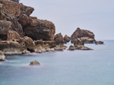 a body of water with rocks in the background