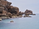 a body of water with rocks in the background