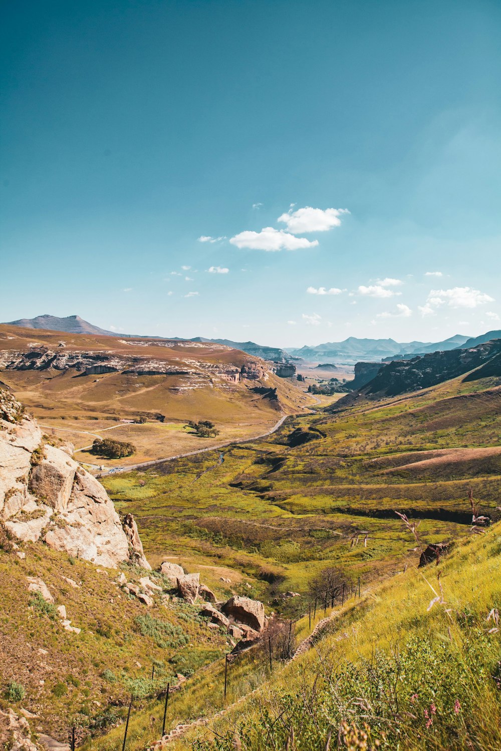 a scenic view of a valley with mountains in the background