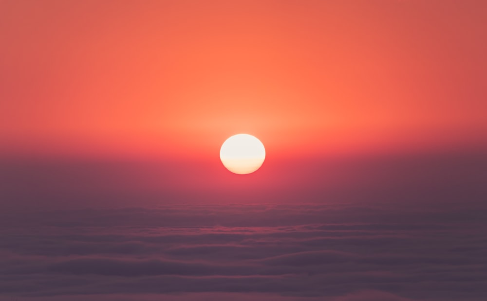 the sun is setting over the clouds in the sky