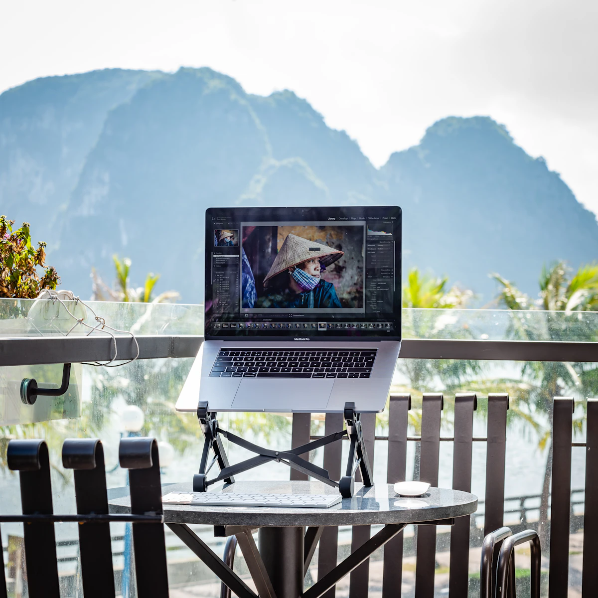 Digital nomad working on a laptop with a coastal view in the background