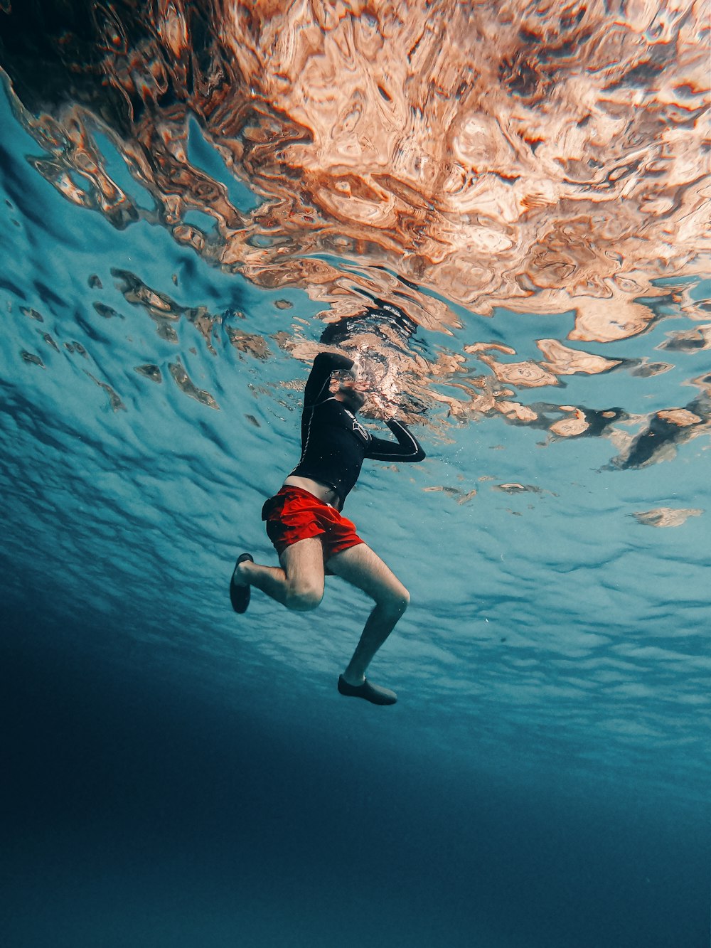 a man in a wet suit swimming under water