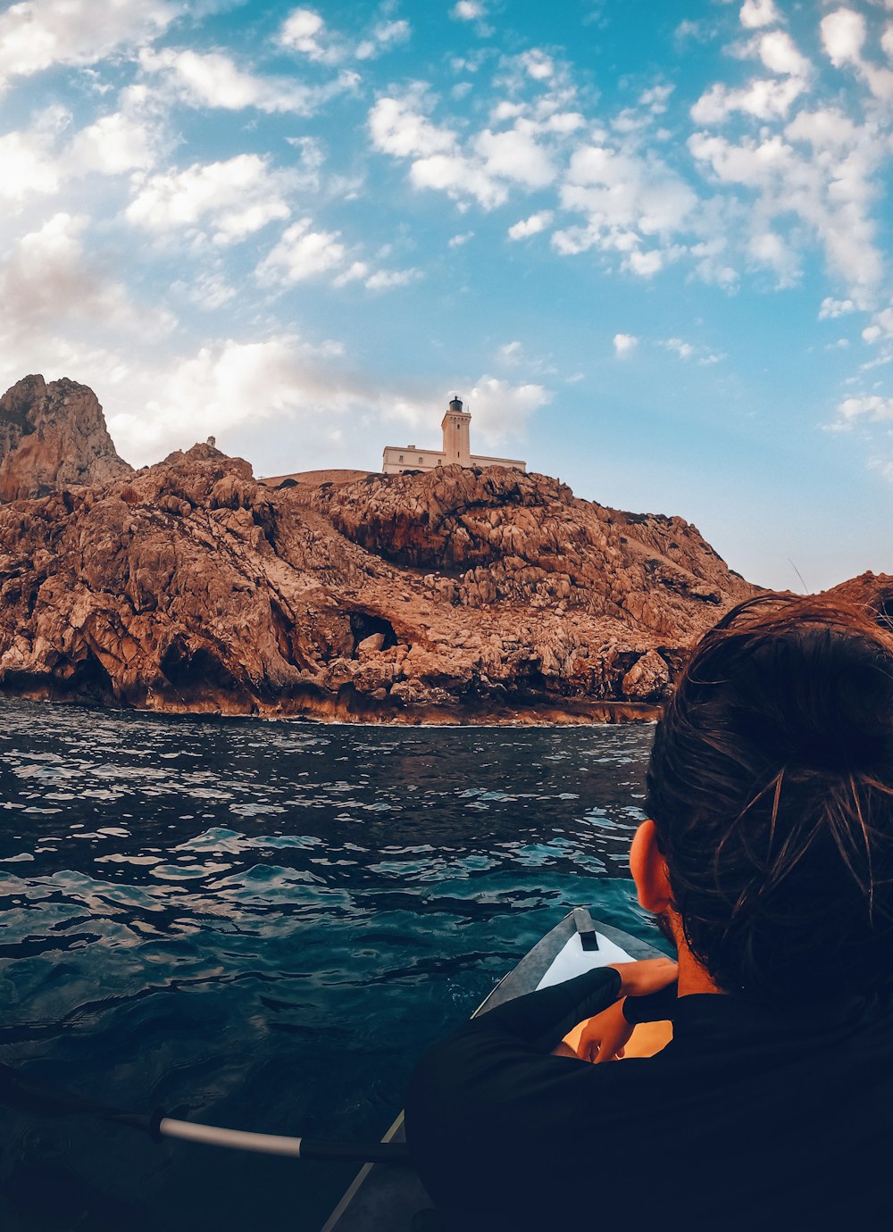 a person in a kayak in front of a rocky island