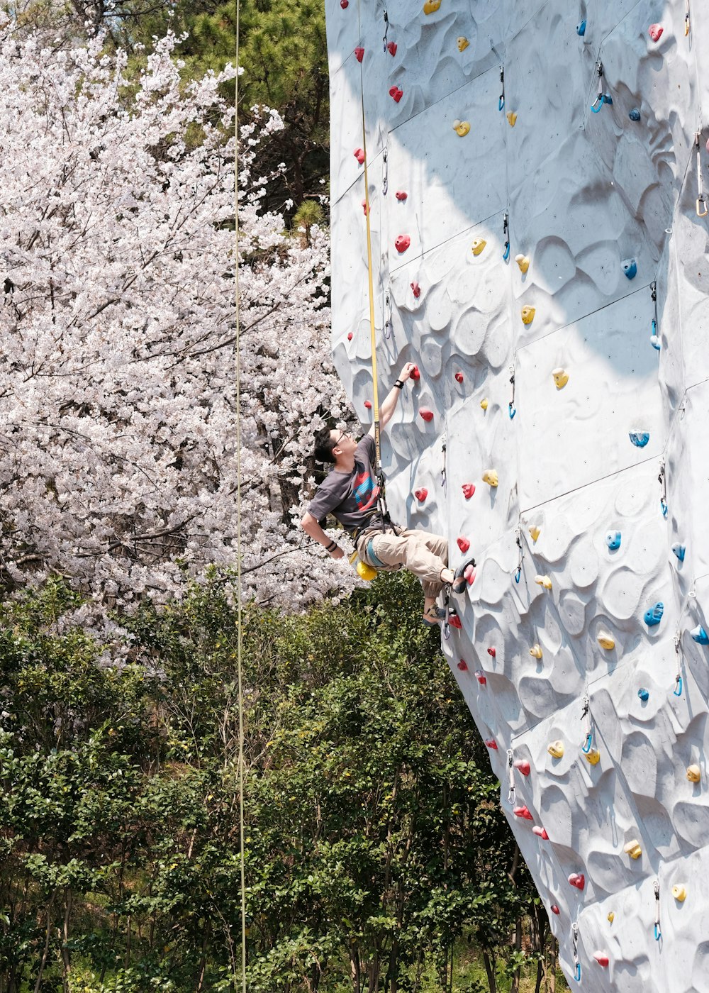 a man climbing up the side of a climbing wall