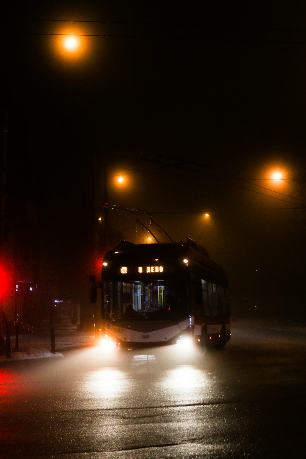 a bus driving down a street at night