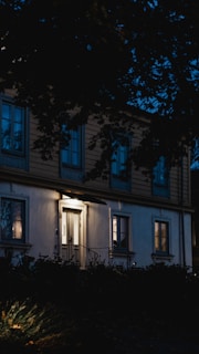 A welcoming front entrance of a cozy apartment building with warm lighting at dusk.