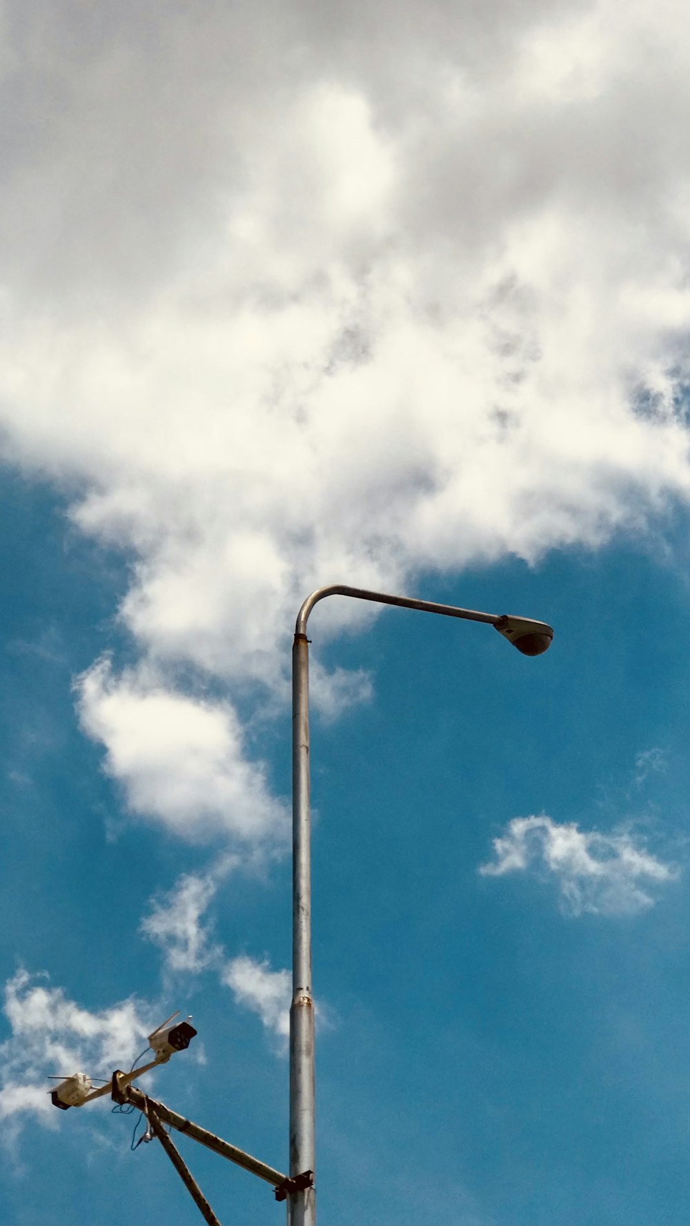 eine Straßenlaterne mit bewölktem Himmel im Hintergrund