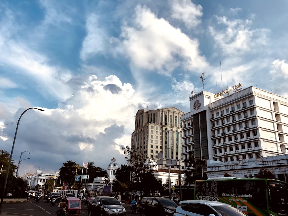 a city street filled with lots of traffic under a cloudy sky