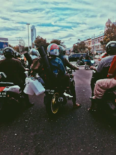 A motorcycle taxi waiting by a busy corner with passengers in Santo Domingo.
