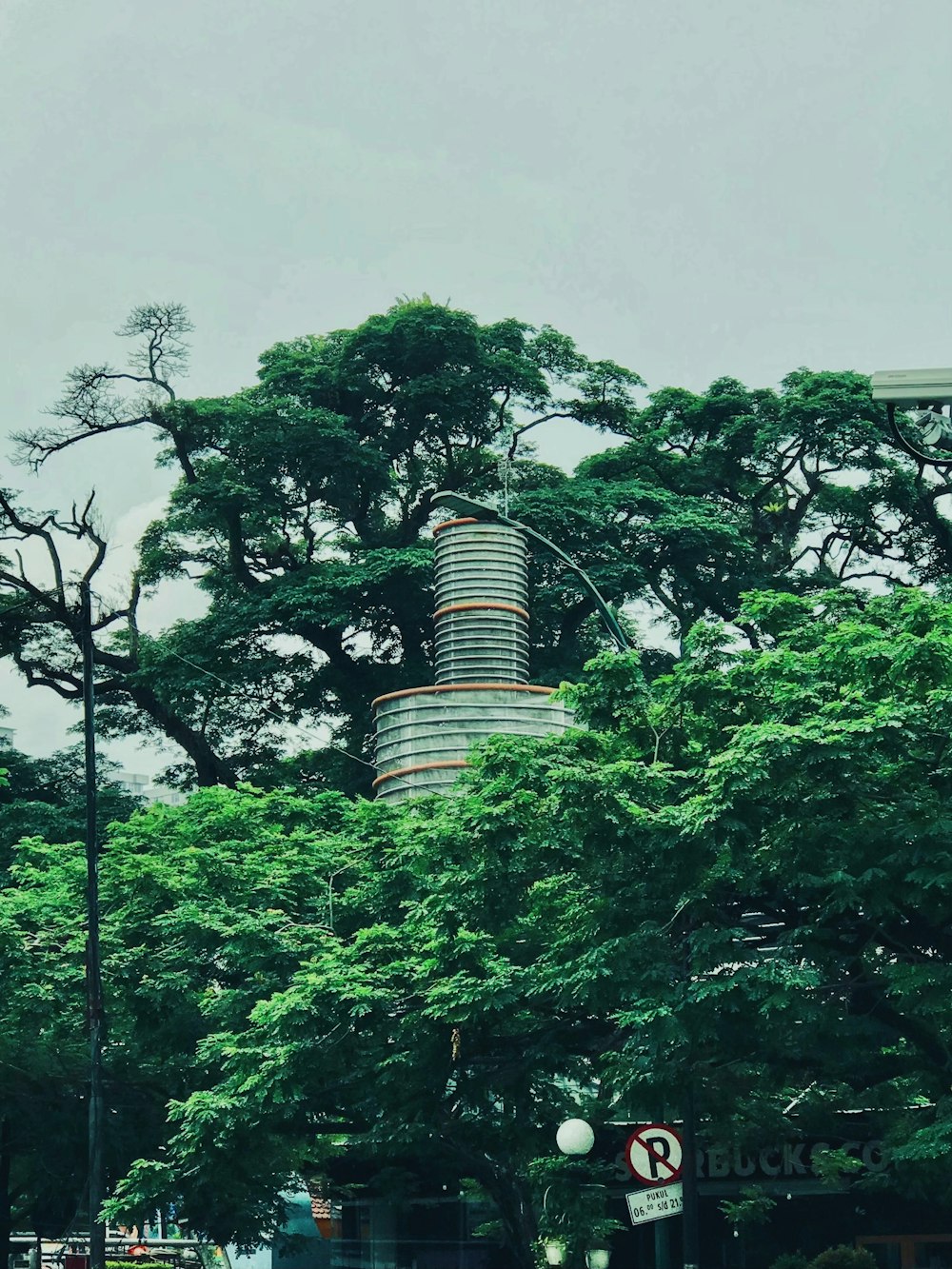 a tall building sitting next to a lush green forest