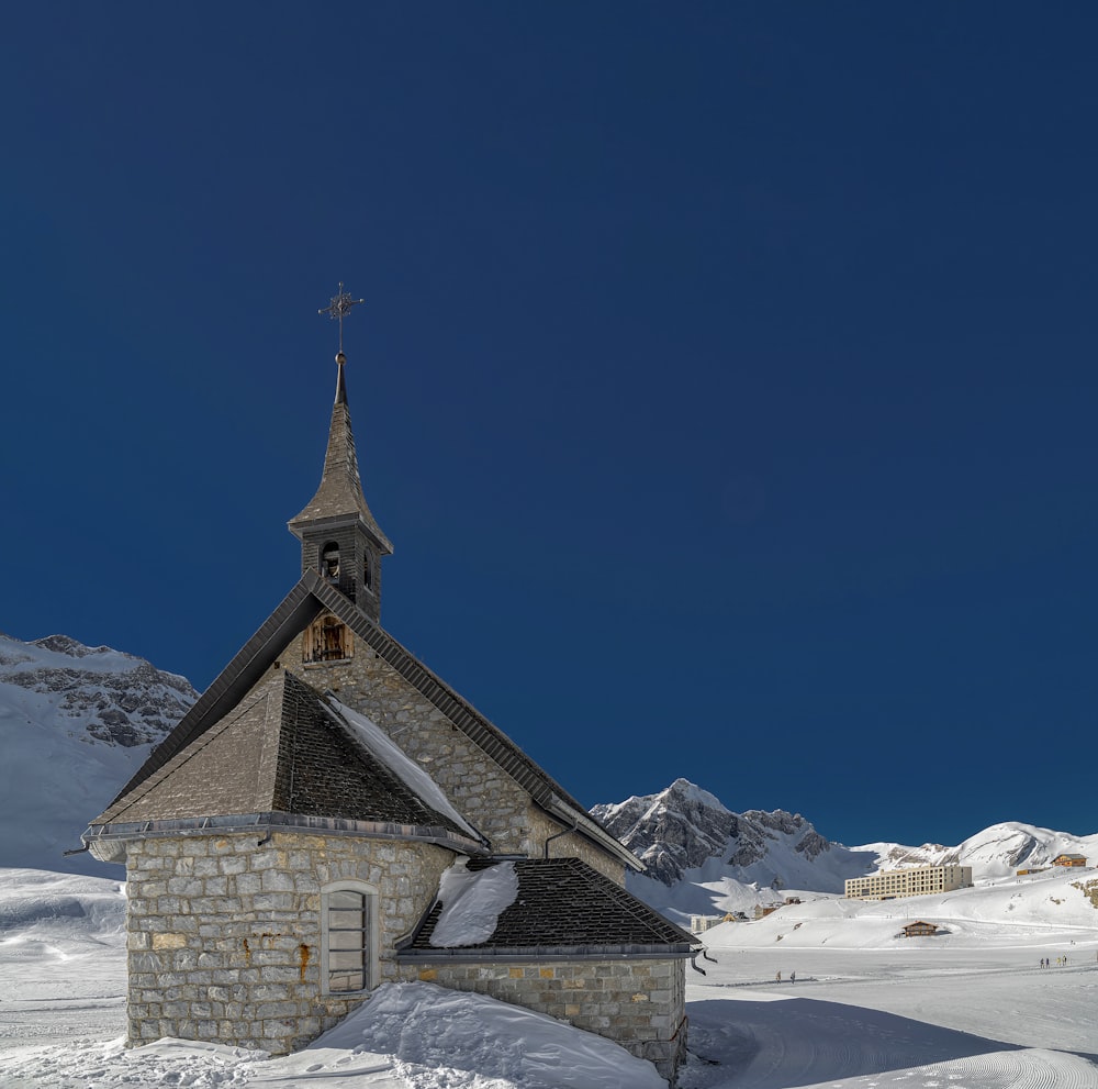 a small church with a steeple in the snow