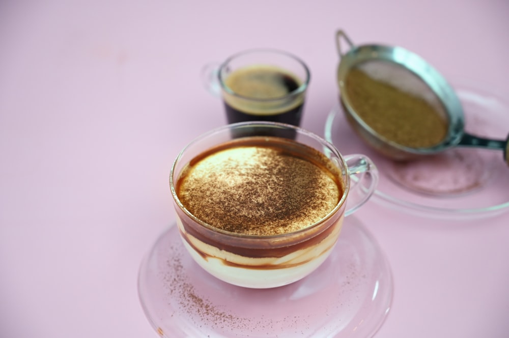 two cups of coffee on a saucer on a pink table