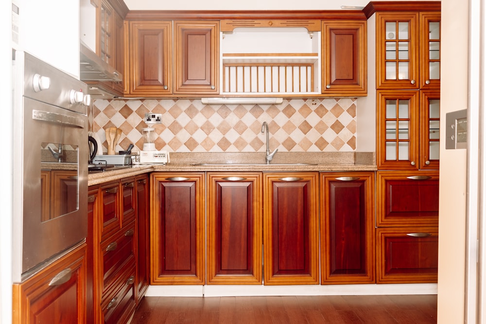una cocina con gabinetes de madera y un refrigerador de acero inoxidable