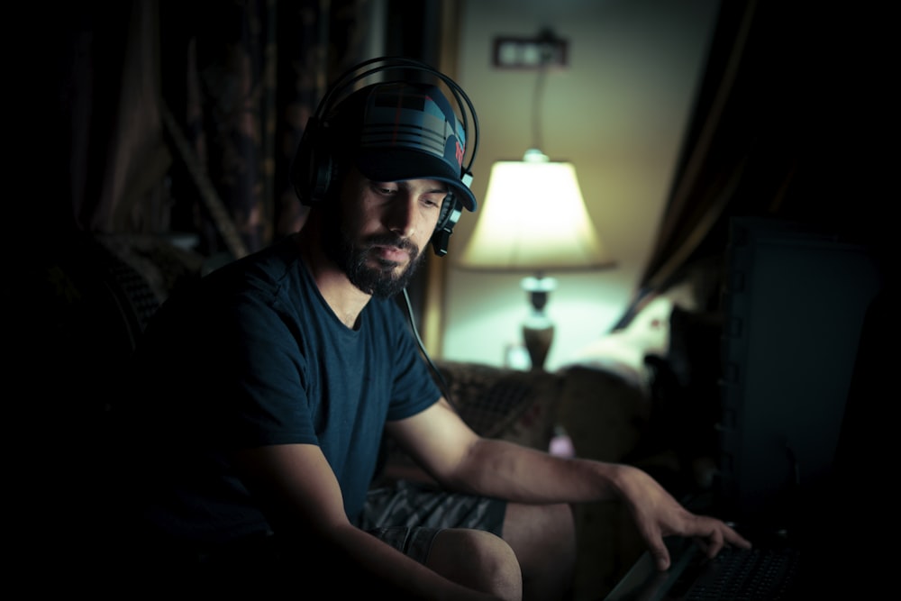 a man sitting on a couch using a laptop computer