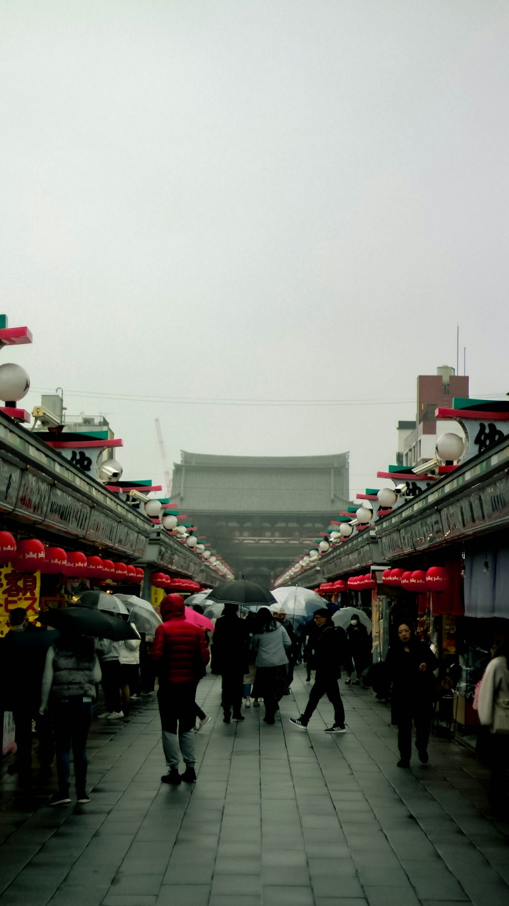 a group of people walking down a street under umbrellas