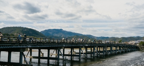 Hikers crossing a wooden bridge over a flowing river in a forest