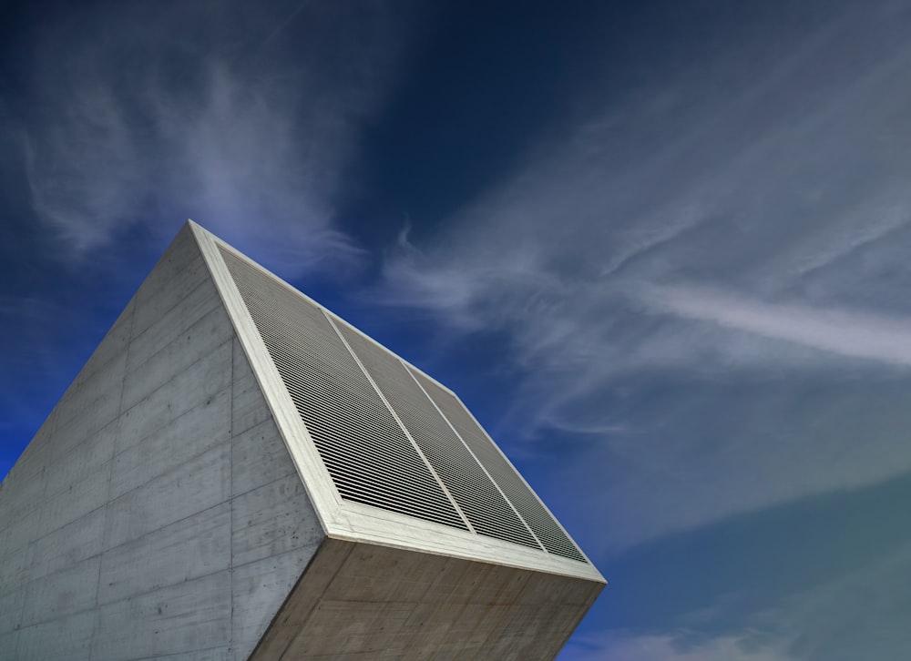 a tall white building sitting under a blue sky