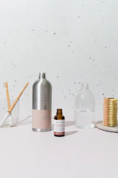 a white table topped with a bottle of liquid and a brush