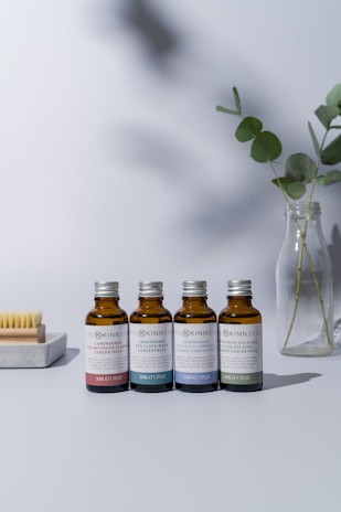 a group of bottles of essential oils next to a plant