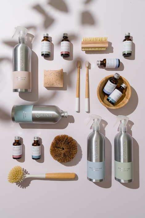 A neat arrangement of common daily use products like soap, snacks, and cleaning supplies on a wooden table.