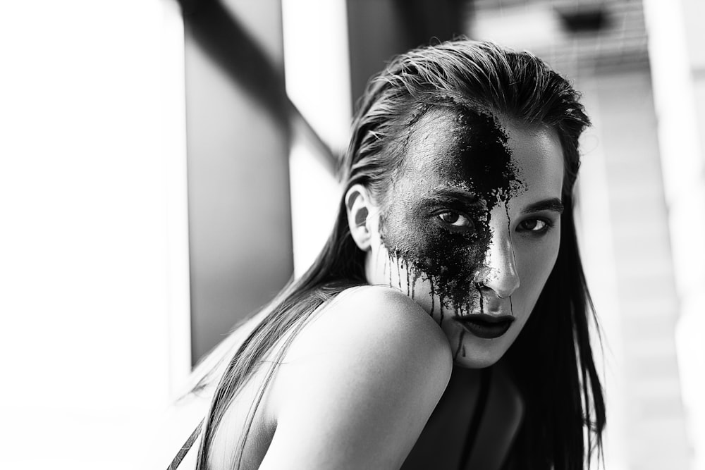 a woman with black paint on her face