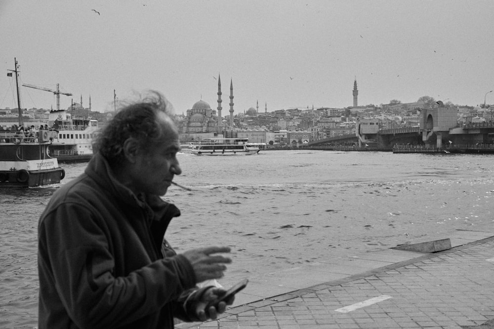 a man standing next to a body of water