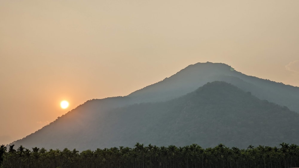 the sun is setting behind a mountain range