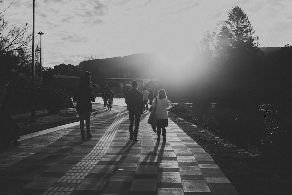 a group of people walking down a sidewalk