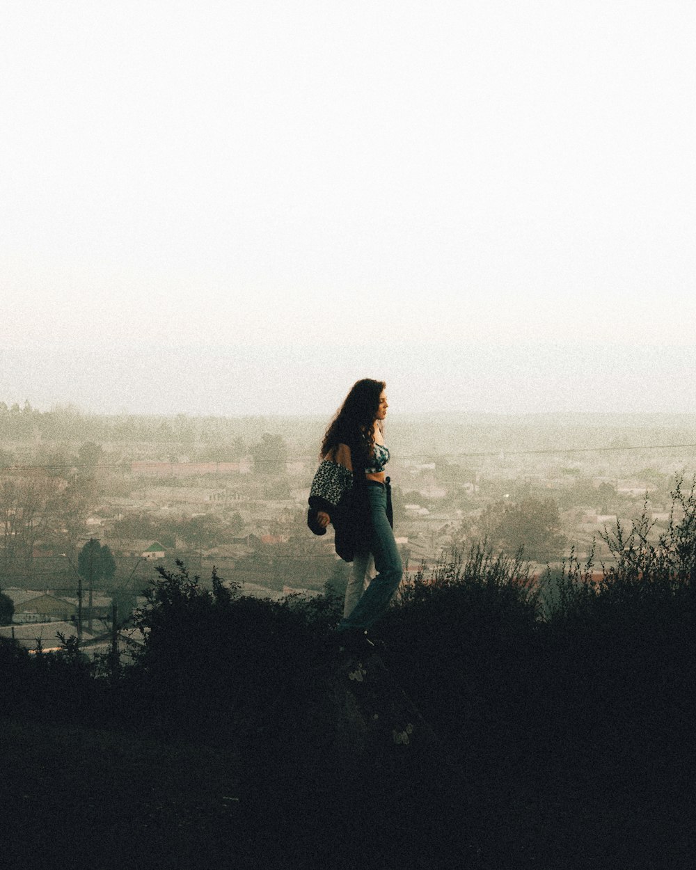 a woman standing on top of a hill