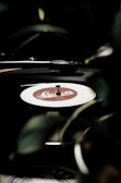 A vinyl record spinning on a turntable with a soft green light illuminating the scene.