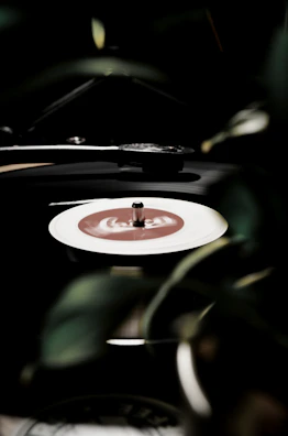 A vinyl record spinning on a turntable with a soft green light illuminating the scene.