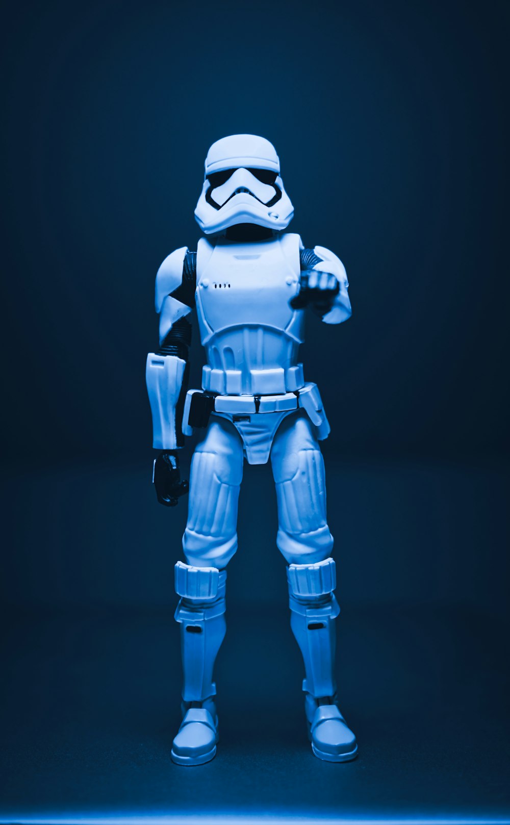 a star wars action figure standing in a dark room