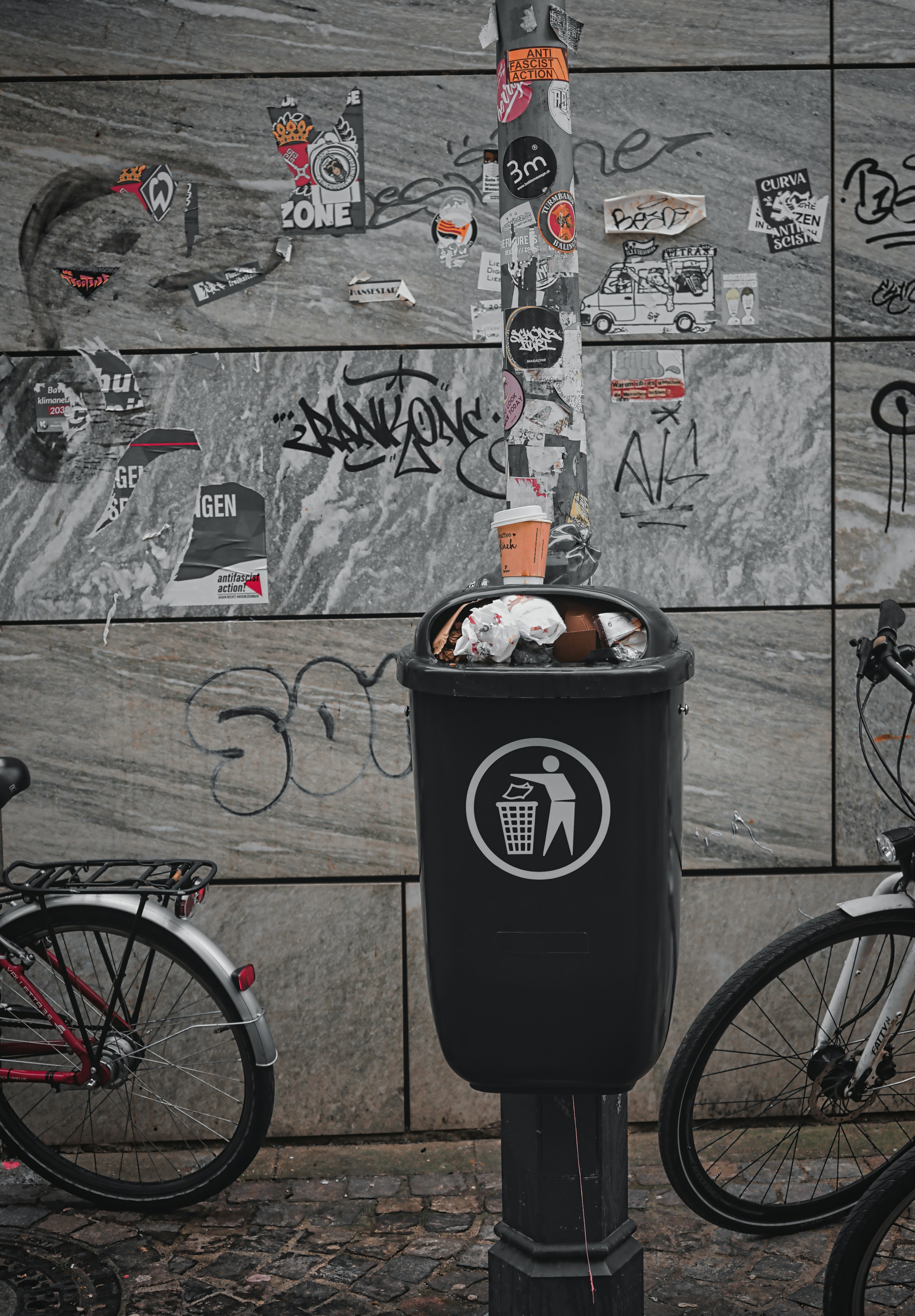 a trash can with a lot of stickers on it