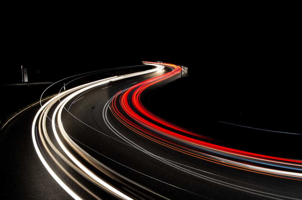 a long exposure photo of a highway at night