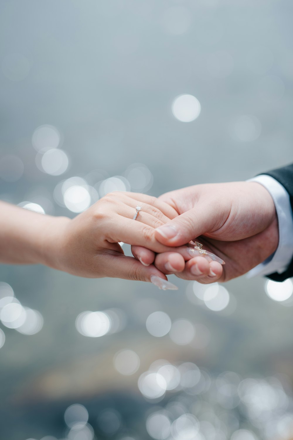 a close up of two people holding hands