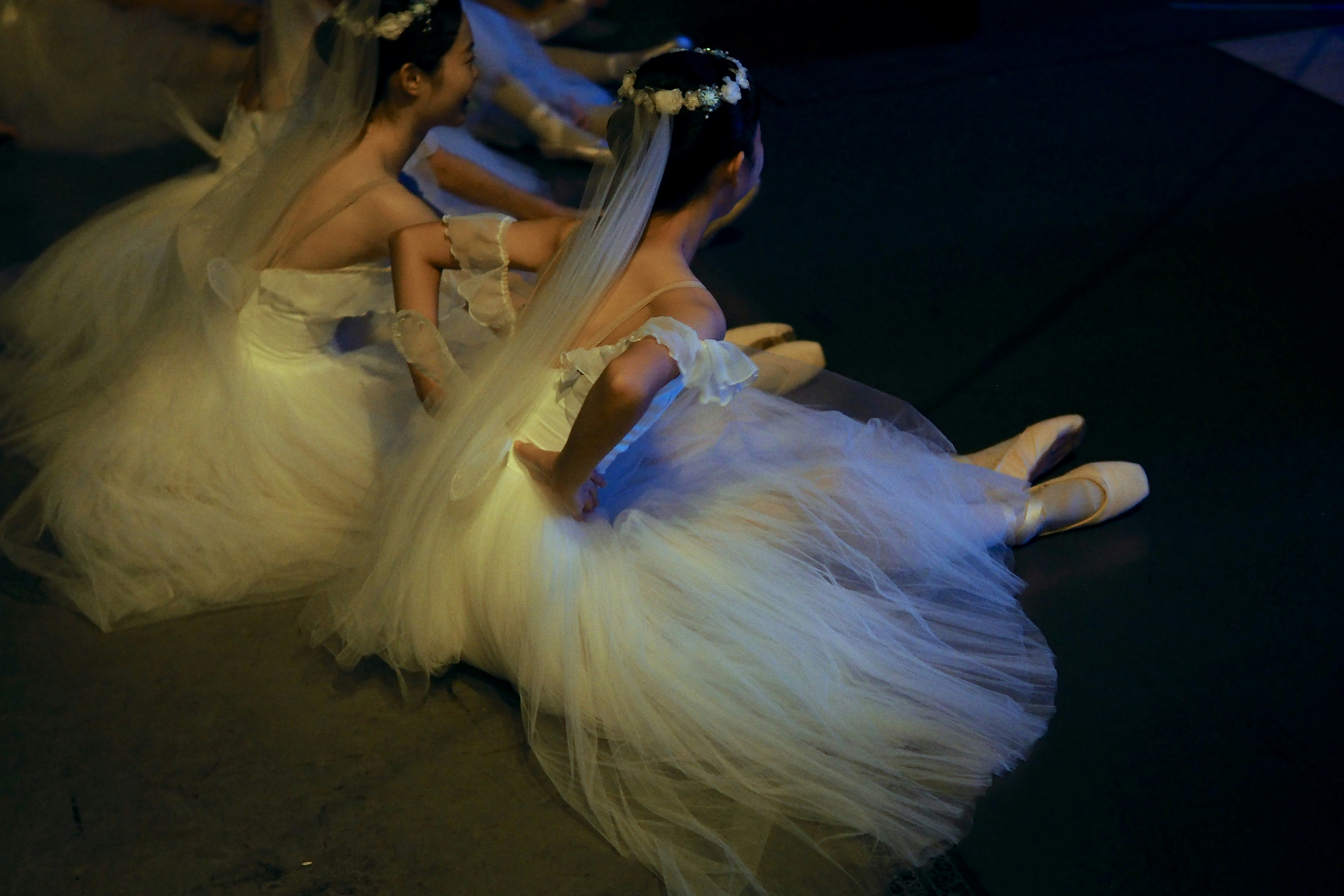 a group of young girls dressed in white dresses
