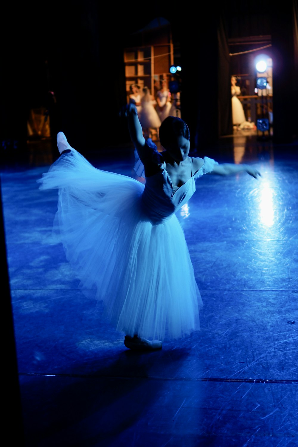 a woman in a white dress is dancing on a stage