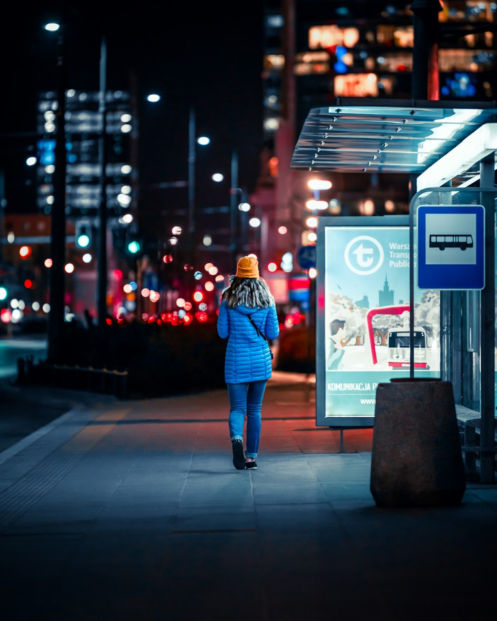 a woman walking down a street at night