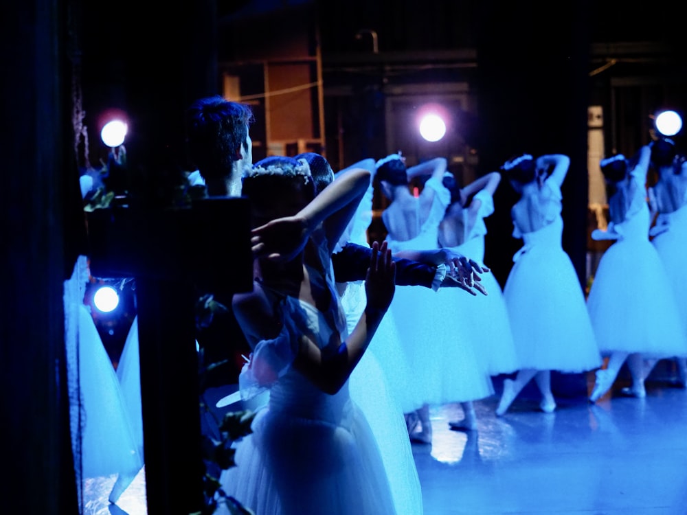 a group of people dressed in white dancing