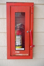 a red fire extinguisher mounted to a wall