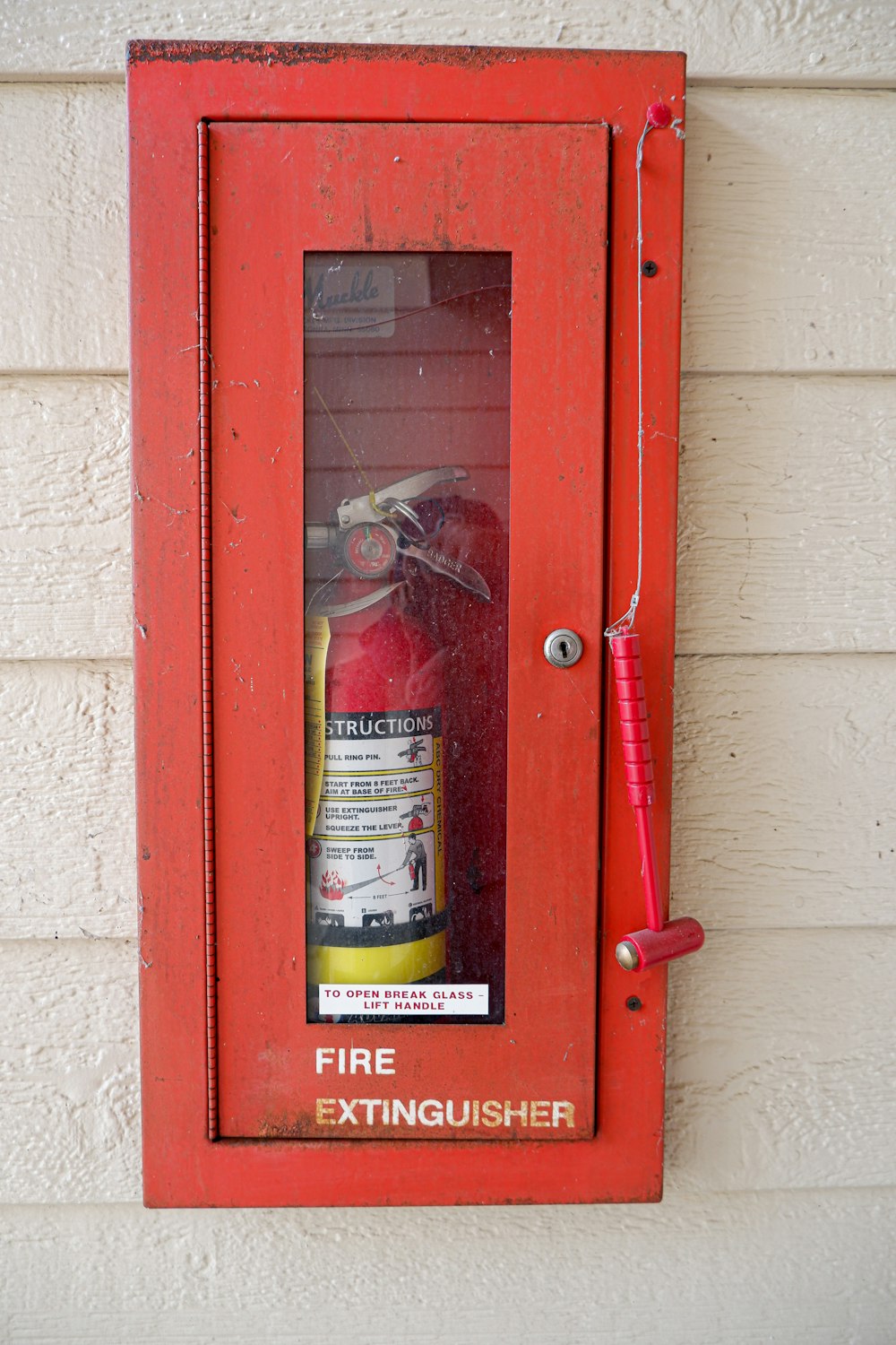 a red fire extinguisher mounted to a wall