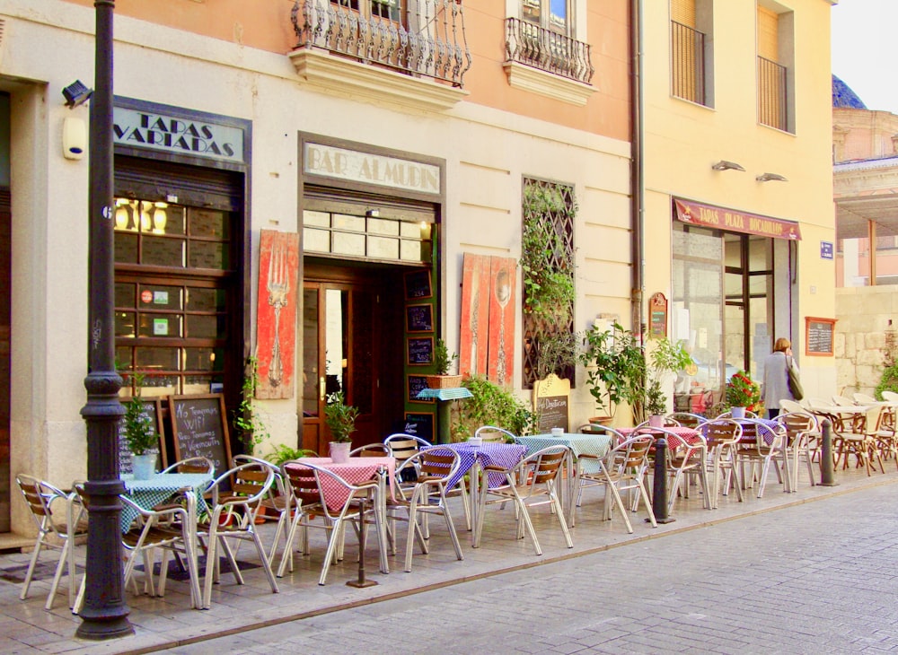 a row of tables and chairs outside of a building