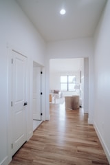 an empty room with white walls and wood floors