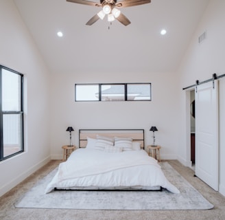 a bedroom with a bed and a ceiling fan