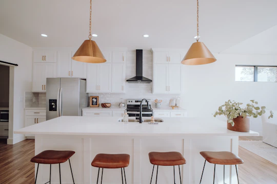 Bright modern kitchen featuring handleless cabinetry and a large island with pendant lighting.