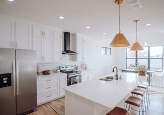 a kitchen with white cabinets and a silver refrigerator