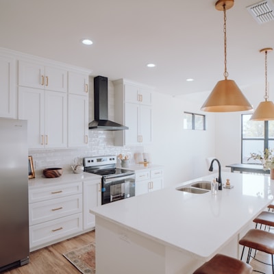 a kitchen with white cabinets and a silver refrigerator