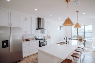 a kitchen with white cabinets and a silver refrigerator